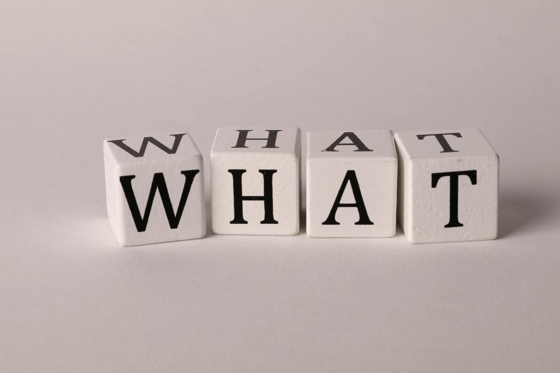 Cubes de lettres pour former le mot What pour dire Quoi en Anglais