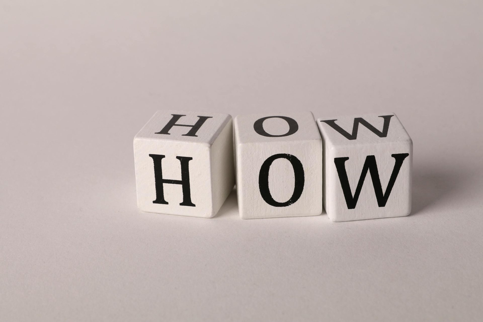 Cubes de lettres pour former le mot How pour dire Comment en Anglais